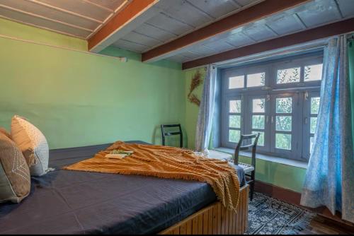 Un dormitorio con una cama grande con ventana. en Mountain eyrie, en Banjār