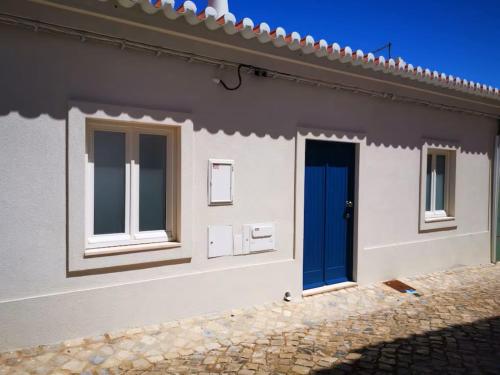 a house with a blue door and windows at River View Ferragudo Terrace Villa in Ferragudo