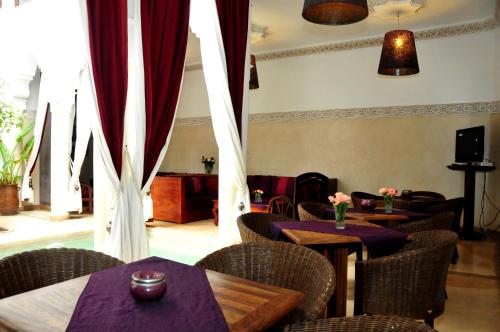 a restaurant with tables and chairs with purple curtains at Riad Elias & Spa in Marrakesh