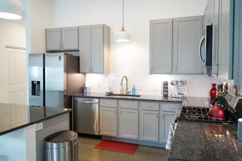 a kitchen with white cabinets and stainless steel appliances at Penn Street Retreat in Lawrence