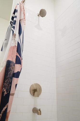 a bathroom with a shower with a shower curtain at The Sunflower Suite in Lawrence