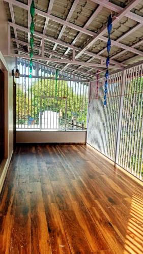 an empty room with a large window and a wooden floor at Shri Hari Villa in Patwa Dunga