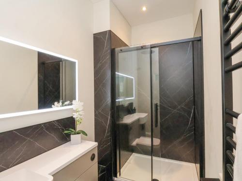 Un baño con ducha de cristal y un inodoro. en The Salisbury - 1 Bedroom Deluxe Apartment, en Scarborough
