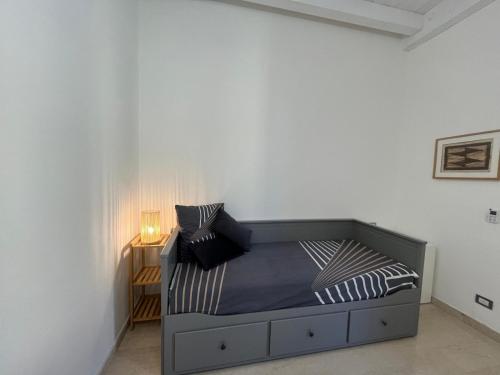 a bed in a white room with a night stand at Red Leaf in Como