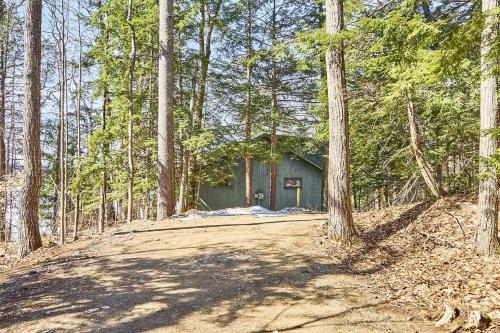 a house on a dirt road in the woods at Lakeside Getaway - Lake Access & Firepit in Wolfeboro