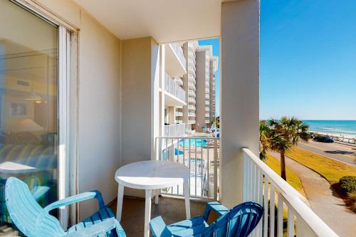 a balcony with a table and chairs and the beach at Majestic Sun B0206 in Destin