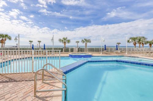 a large swimming pool with palm trees and the ocean at Majestic Sun B0206 in Destin