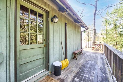 a porch of a house with a door and a bench at Lakeside Getaway - Lake Access & Firepit in Wolfeboro