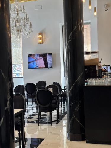 a dining room with black chairs and a chandelier at Adriano Boutique Sevilla in Seville