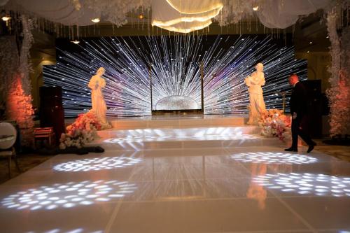 a man walking down a stage with three dresses on it at Oriental grand Plaza in Madinat Al Ashir min Ramadan