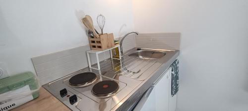 Il comprend une petite cuisine équipée d'une cuisinière et d'un évier. dans l'établissement Chambre avec Kitchenette, à Évran
