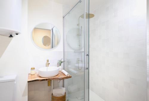 une salle de bain blanche avec un lavabo et une douche dans l'établissement Studio rénové, 5mn plage, terrasse, clim, vélos, à Saint-Mandrier-sur-Mer