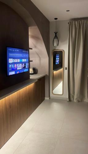 a living room with a tv and a refrigerator at Incanto Luxury Suites 2 in Nafpaktos