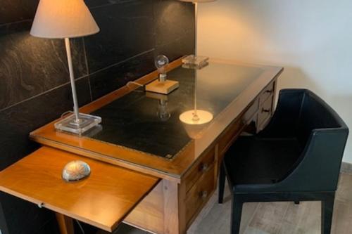 un bureau en bois avec une lampe et une chaise dans l'établissement charmante maison avec jardin clos sur les dunes de Sainte Marguerite avec SPA en option, à Landéda