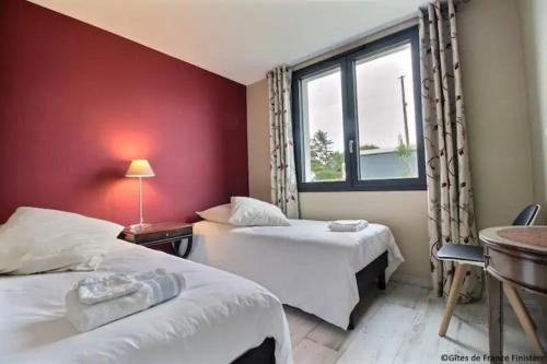 une chambre d'hôtel avec deux lits et une fenêtre dans l'établissement charmante maison avec jardin clos sur les dunes de Sainte Marguerite avec SPA en option, à Landéda