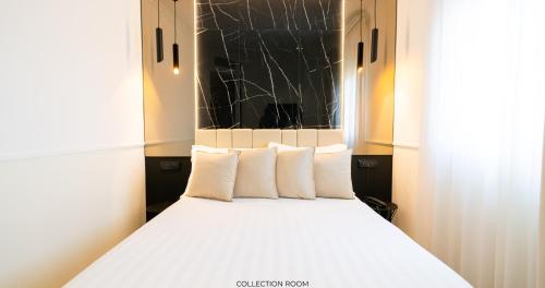 a bed with white pillows in a room at Hotel Windrose in Rome