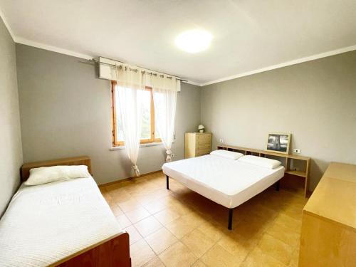 une chambre avec deux lits et une fenêtre dans l'établissement Casa Millo a Marina di Cecina by Zoom In Earth, à Marina di Cecina