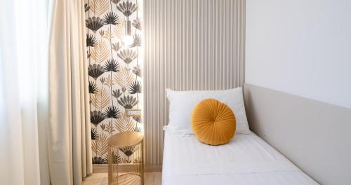 a bedroom with a bed with a yellow pillow on it at Hotel Windrose in Rome