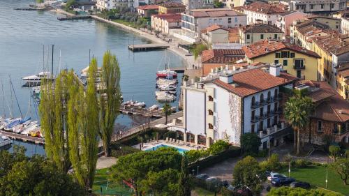 a city with a marina and boats in the water at Bellerive Lifestyle Hotel in Salò