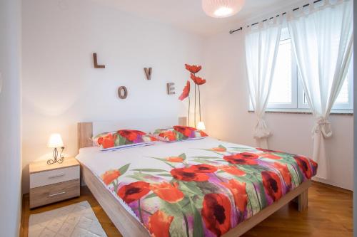 1 dormitorio con 1 cama con un edredón colorido en Apartment Soni A4, en Krk