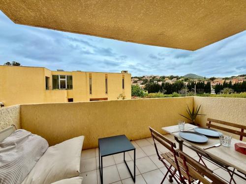 - un balcon avec une table et des chaises dans l'établissement Central - Terrasse - Vue montagne, à Carqueiranne