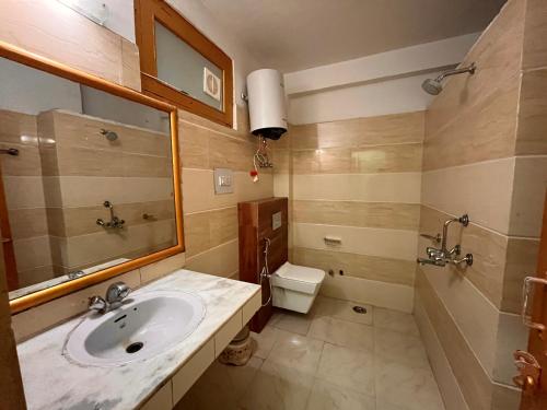 a bathroom with a sink and a toilet at Naina Spring Resort, Manali - away from city hustle in Manāli