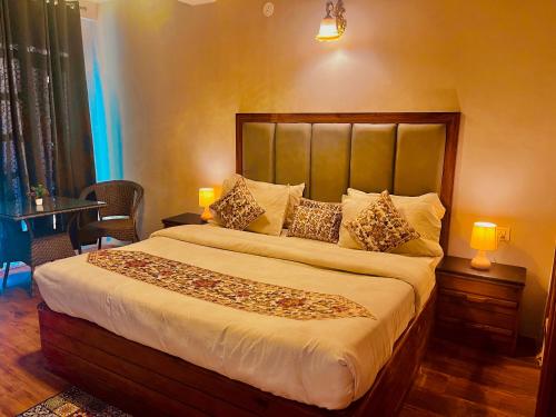 a bedroom with a large bed with two lamps at Naina Spring Resort, Manali - away from city hustle in Manāli
