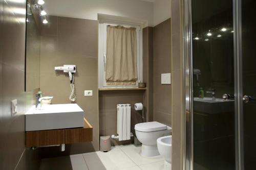 a bathroom with a toilet and a sink and a shower at APPARTAMENTO LAVINIO - Spacious, bright, and thoroughly outfitted with modern amenities - just 150 m from the sea in Anzio