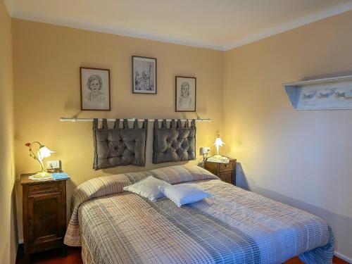 ein Schlafzimmer mit einem Bett mit einer Decke und 2 Tischen in der Unterkunft Ca'del Gasperin in Claino