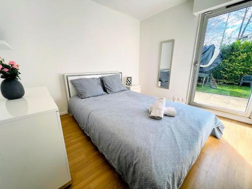 une chambre avec un lit avec deux serviettes dessus dans l'établissement Duplex with Private Garden, Lake Access Paris and Disney, à Torcy