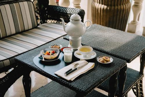 a table with a tea kettle and bowls of food on it at Maison Matilda - Luxury Rooms in Treviso