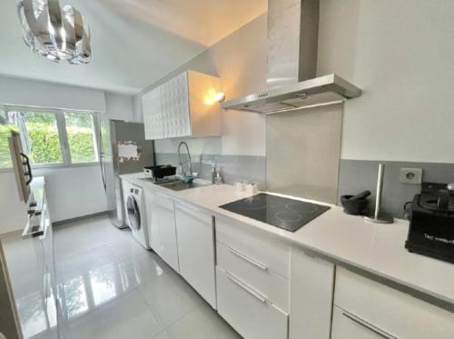 une cuisine blanche avec un évier et un lave-vaisselle dans l'établissement Duplex with Private Garden, Lake Access Paris and Disney, à Torcy