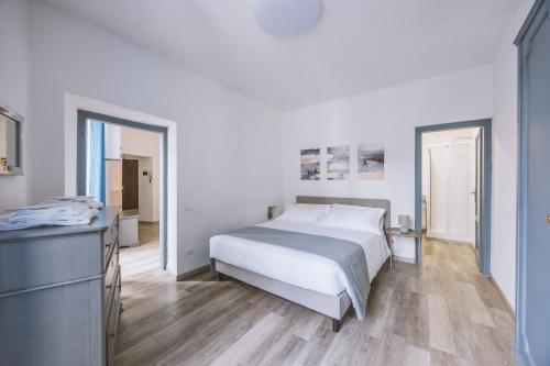 a white bedroom with a bed and a dresser at BHR - Appartamento dell'Anfiteatro in Spoleto