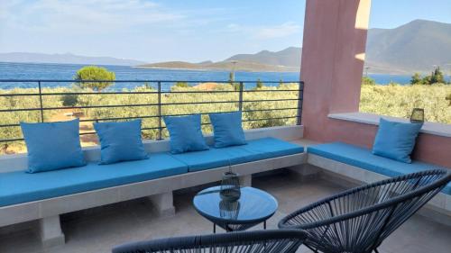 a bench on a balcony with a view of the water at Aelia Stone Houses in Soúrpi