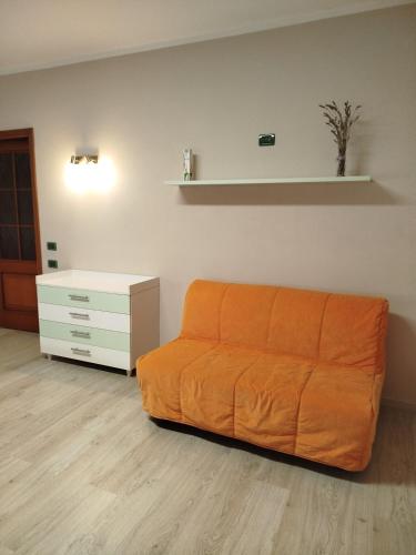 an orange couch in a living room with a dresser at Casa Rossy in Pieve San Giacomo
