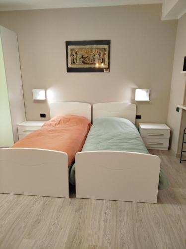 a bedroom with a bed and two white chairs at Casa Rossy in Pieve San Giacomo