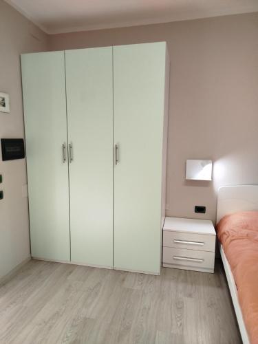 a white bedroom with a bed and a white cabinet at Casa Rossy in Pieve San Giacomo