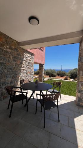 a table and chairs on a patio with a view at Aelia Stone Houses in Soúrpi
