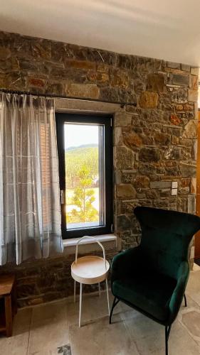 a living room with a chair and a window at Aelia Stone Houses in Soúrpi