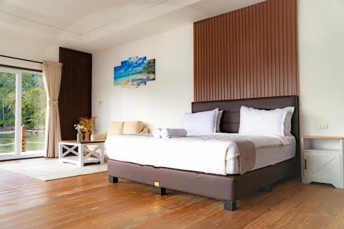 a bedroom with a large bed with a wooden headboard at The Hawk's Nest Resort in Sabong