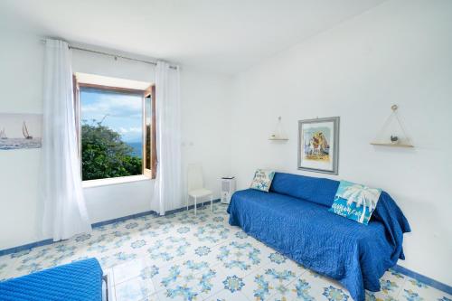 a bedroom with a blue bed and a window at Villa Gianna "Nonna Gianna's Home Amalfi Coast" in Conca dei Marini