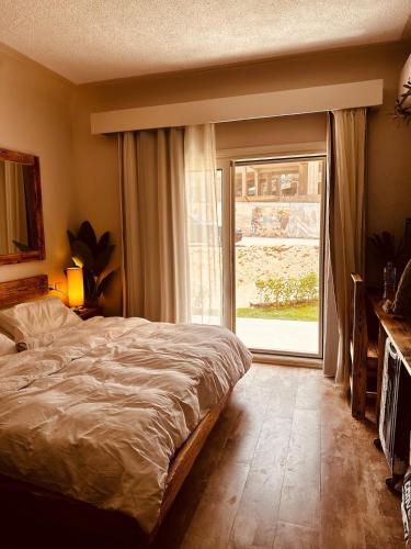 ein Schlafzimmer mit einem Bett und einem großen Fenster in der Unterkunft Yari serenity spot in Raʼs Matarma