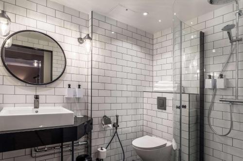 a bathroom with a sink toilet and a mirror at Scandic Helsinki Airport in Vantaa