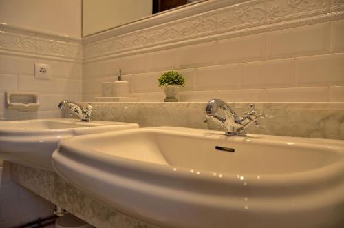 a white bathroom with two sinks and a mirror at Casa Rural Finca Buenavista in Valdeganga de Cuenca
