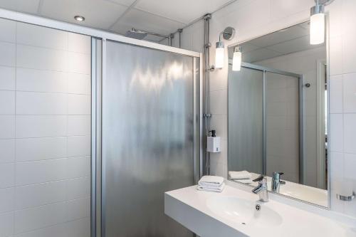 a bathroom with a sink and a shower at Scandic Meilahti in Helsinki