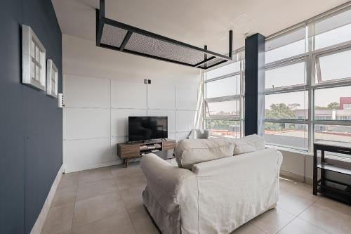 a living room with a couch and a tv at Bed in mixed room Hippie Nice in Mexico City