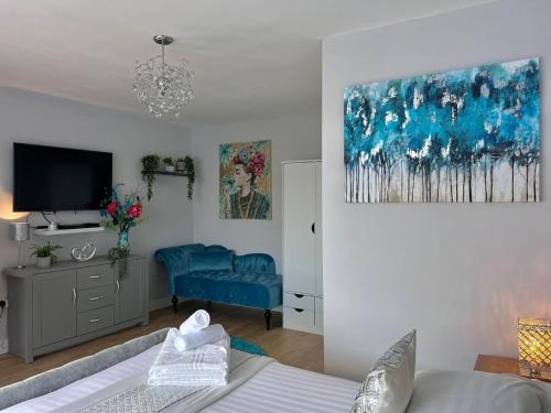 a room with a bed and a tv and a couch at Chic Retreat Apartment Sleeping Two in Loughor