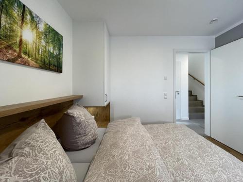 Un dormitorio con una cama y un cuadro en la pared. en Am Dahmer Leuchtturm 23d, en Dahme