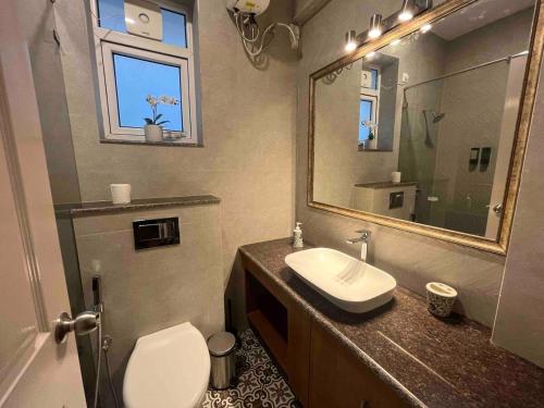 Un baño con lavabo, inodoro y espejo. en The Green Door Villa Varca Beach with Private pool, en Varca