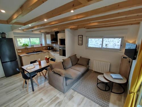 a living room with a couch and a table at Le Pommier Gite neuf avec parking privé clos in Jullouville-les-Pins